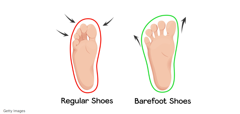 体育館の床に座り、バッシュの踵（かかと）をトントンと床に打ち付けてフィットさせている日本人男性の手元と足元のアップ。正しい靴の履き方の実演。